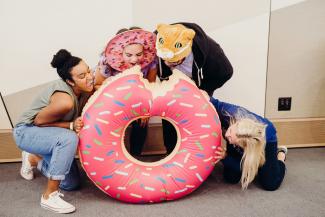 Students pretending to eat a giant inflatable doughnut