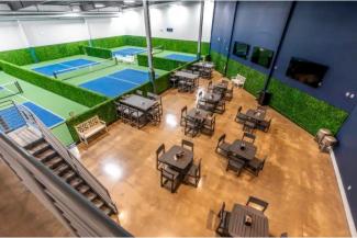 pickle ball courts next to tables and chairs