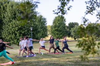 people participating in a yoga class in a field