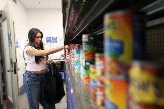 Students selecting items from the Big Blue Pantry shelves
