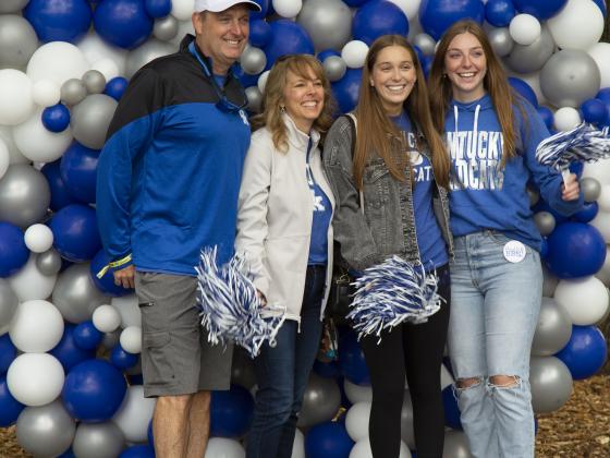 Family posing for photo in front of balloon backdrop